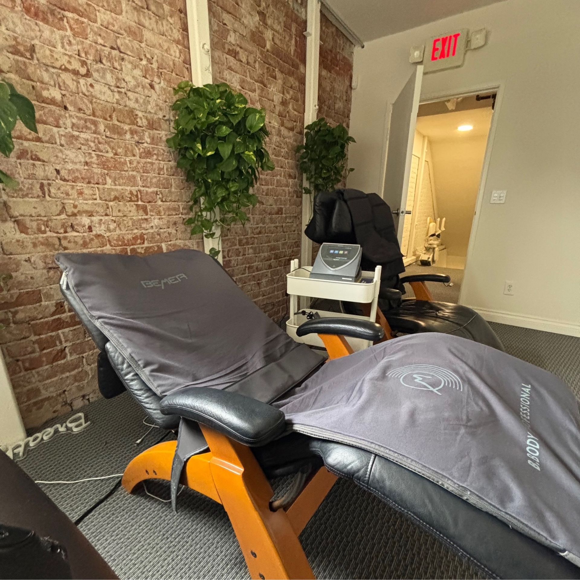 A black massage bed with a treadmill attached to it