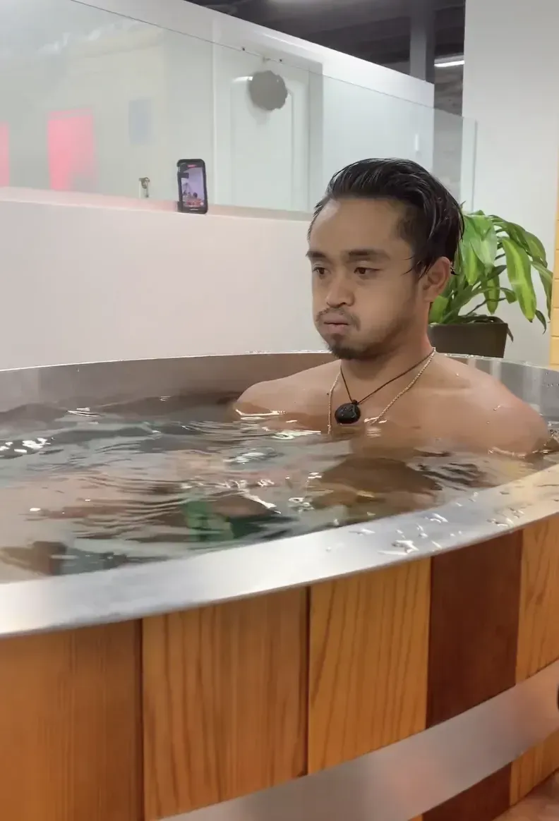 A shirtless man is sitting in a hot tub.
