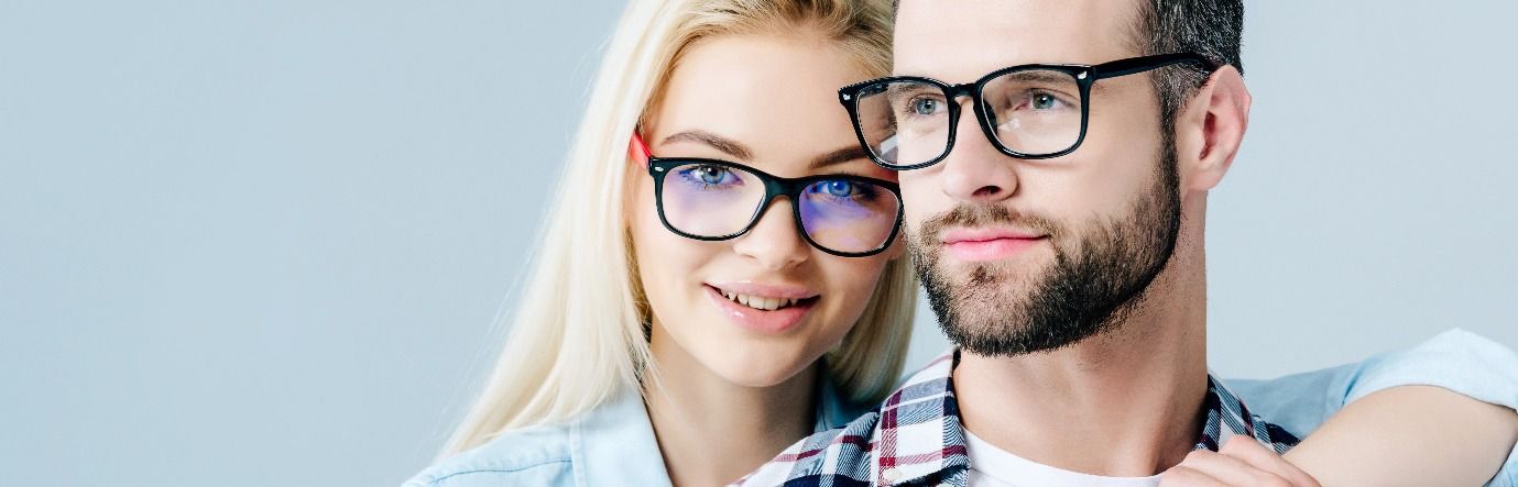Un hombre y una mujer que llevan gafas se abrazan.
