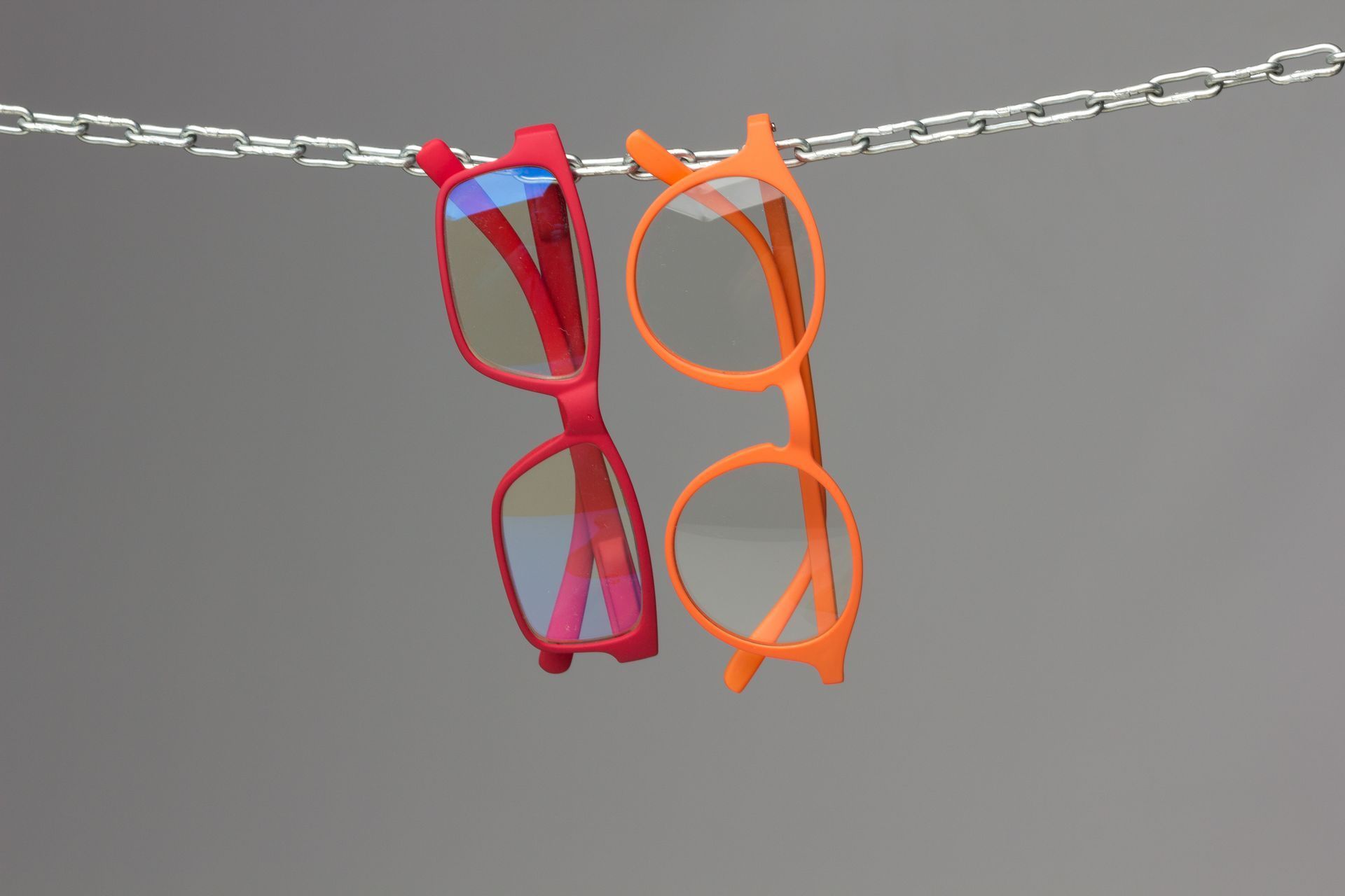 Dos pares de gafas cuelgan de una cadena.