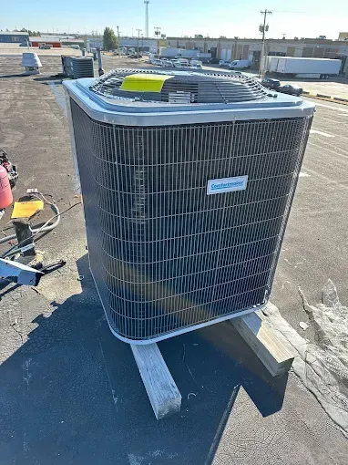 Outdoor air conditioning unit on a rooftop, gray metal with support beams.