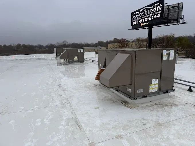 Rooftop scene with HVAC units and a billboard on a cloudy day.