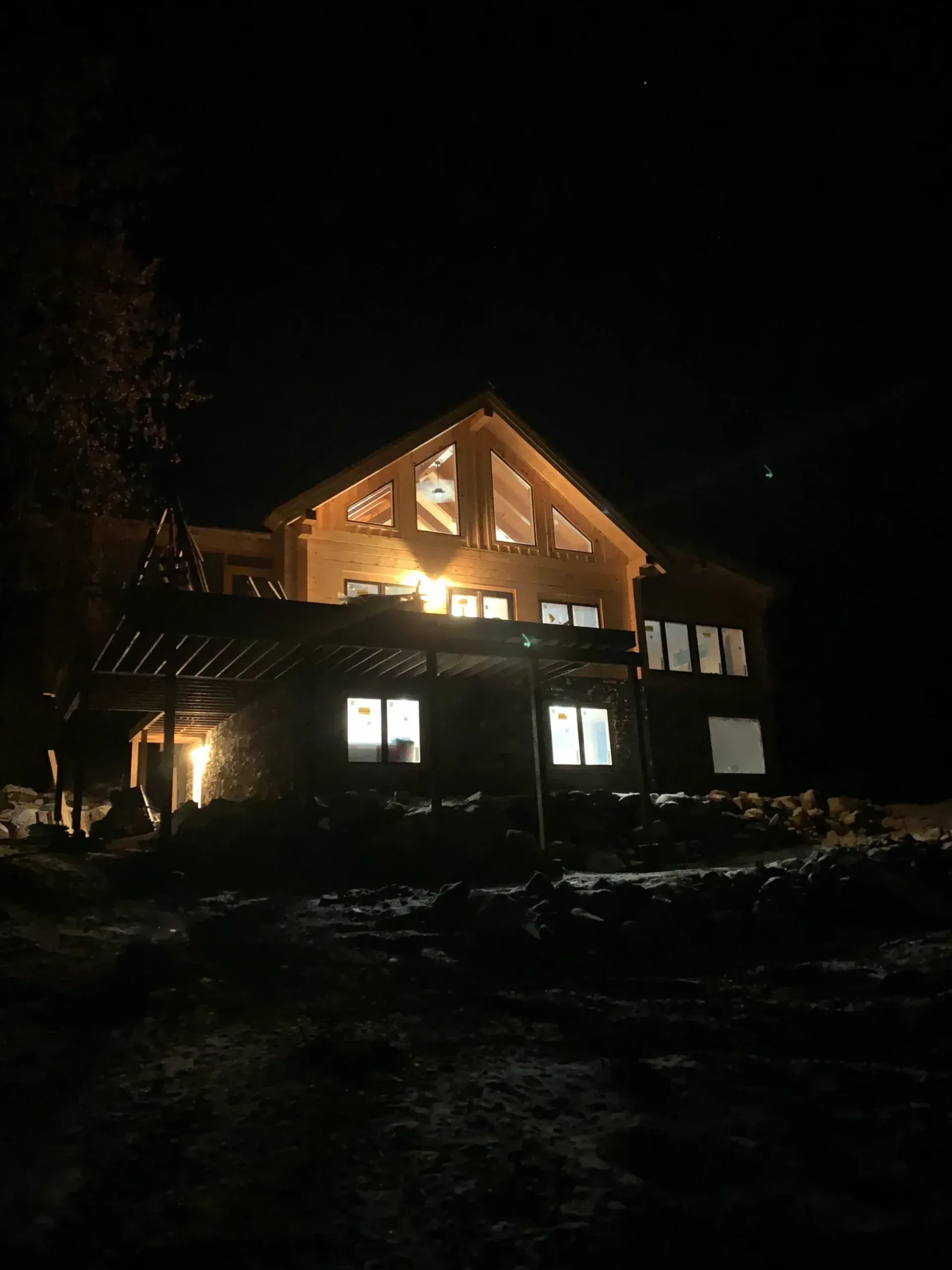A large wooden house is lit up at night.
