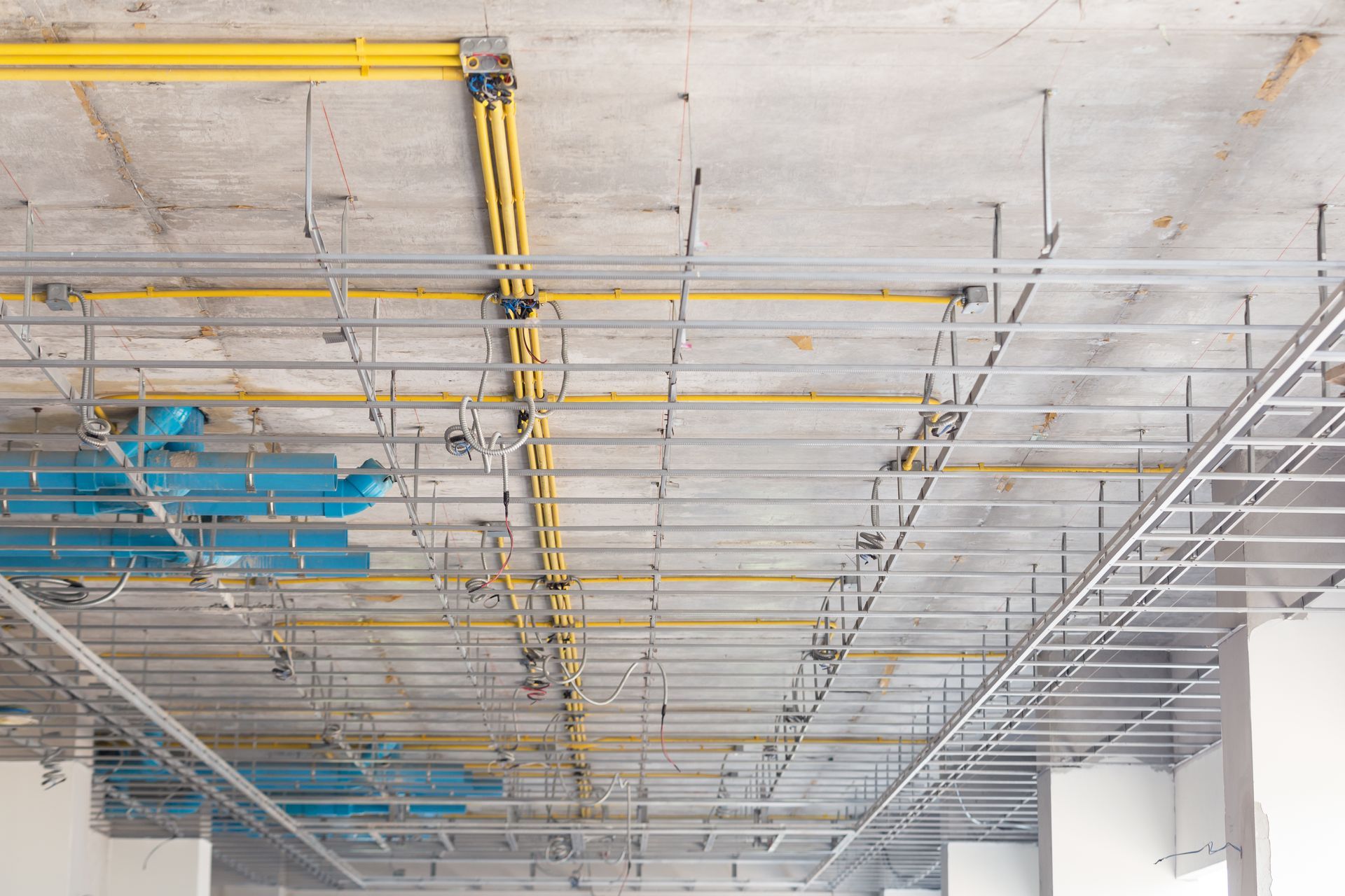 a ceiling with pipes and wires hanging from it