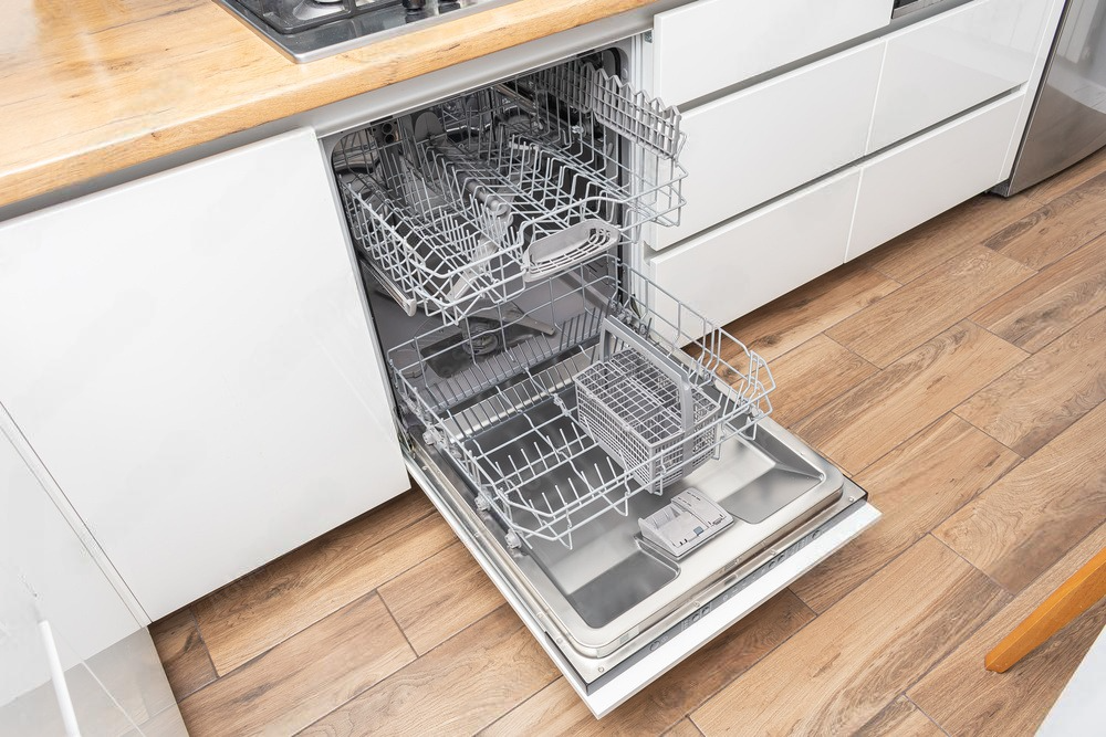 a dishwasher with the door open is filled with dishes