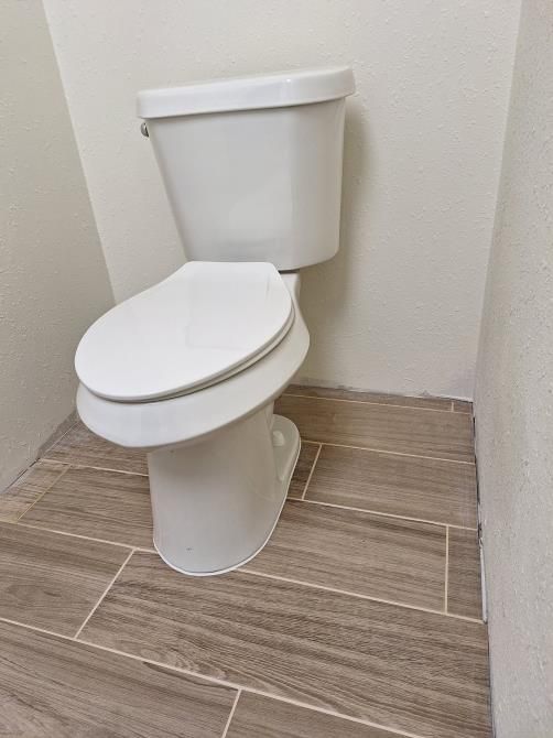 a white toilet with the lid up in a bathroom