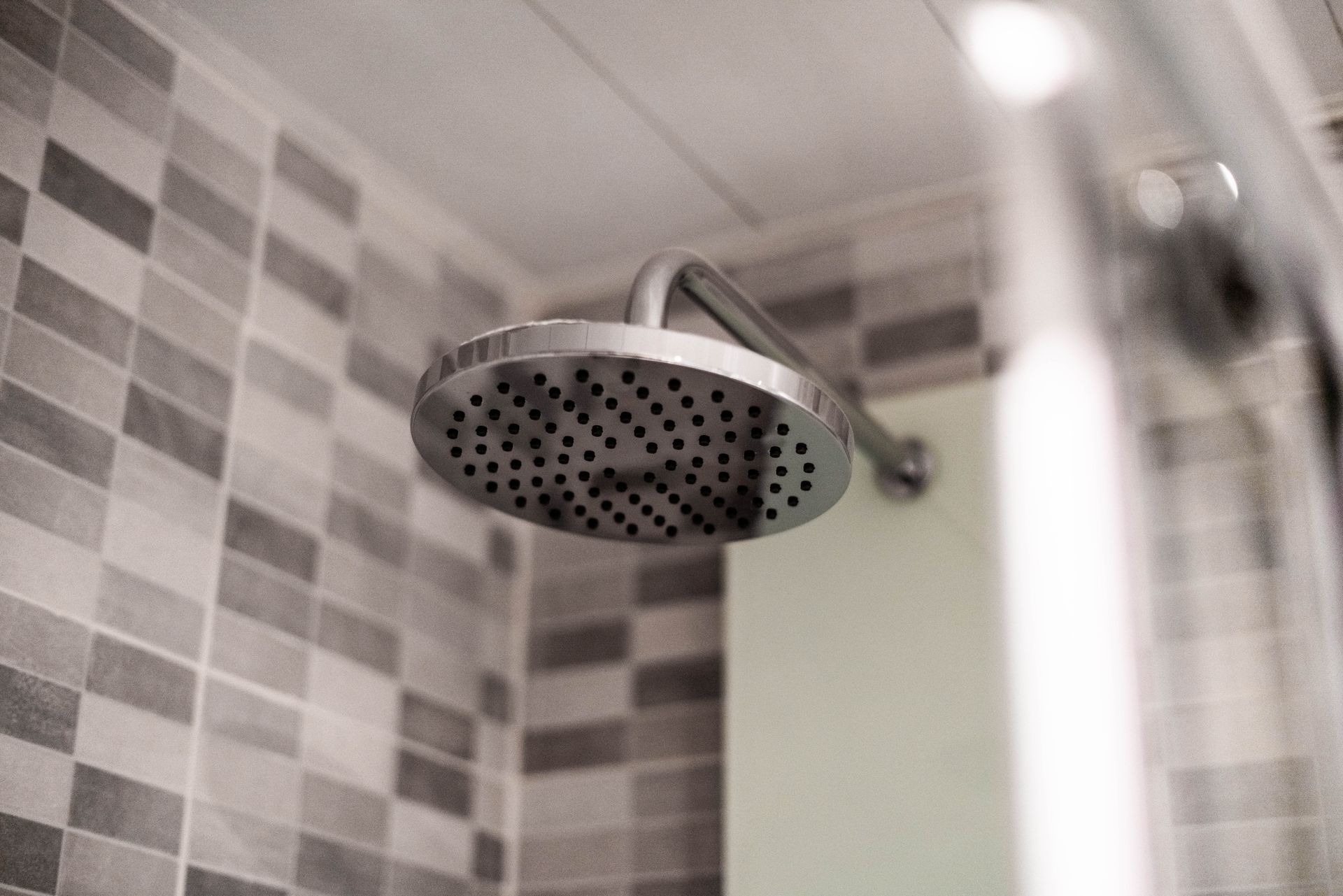 Close-up of a modern, gray stainless steel shower head.