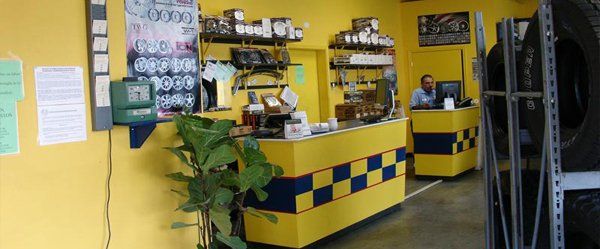 A man is standing at a counter in a tire shop.