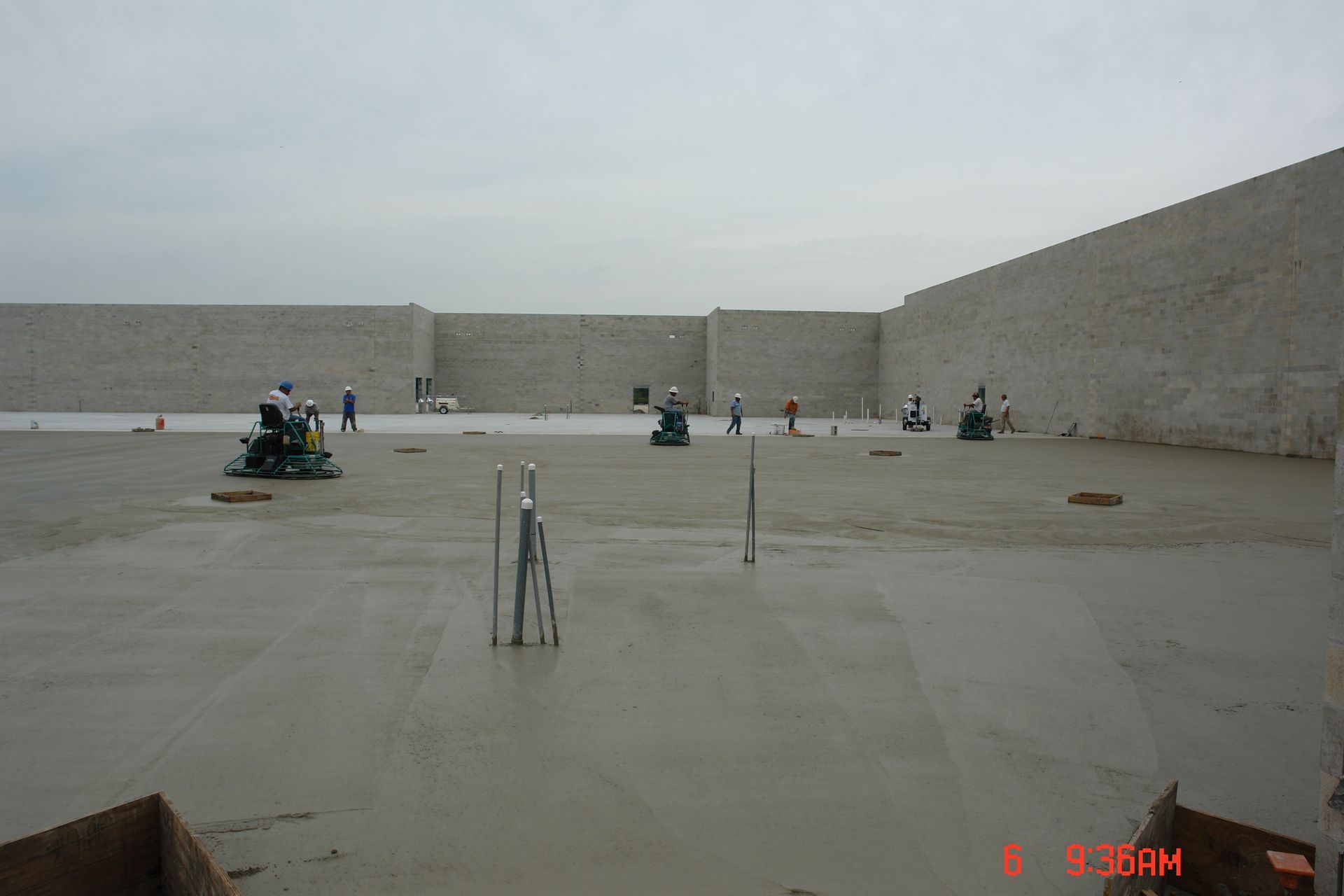 A group of people are working on a concrete floor