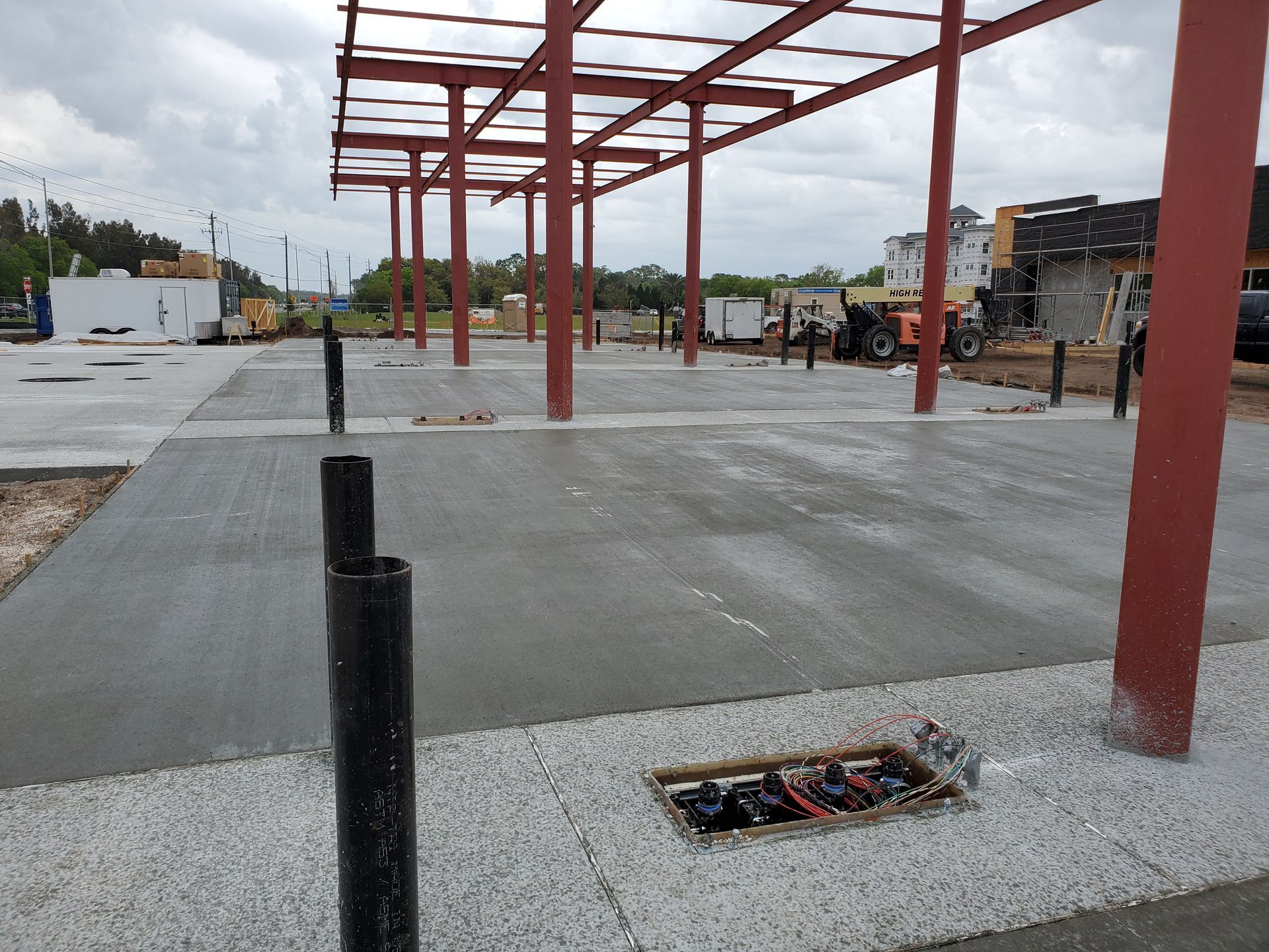 A construction site with a lot of concrete and metal pillars