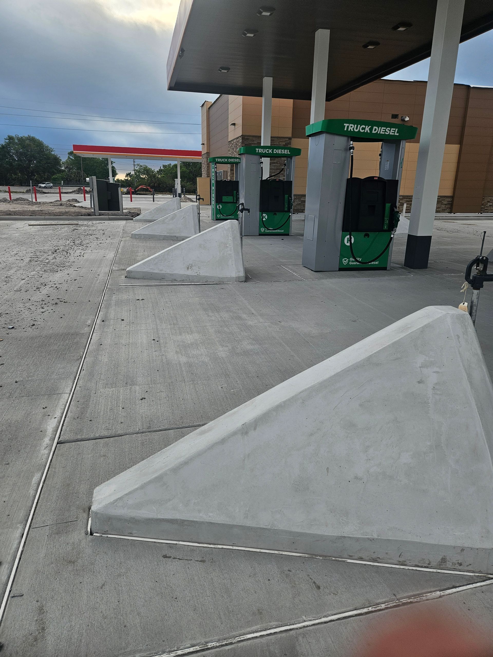 A row of gas pumps are lined up in front of a gas station.