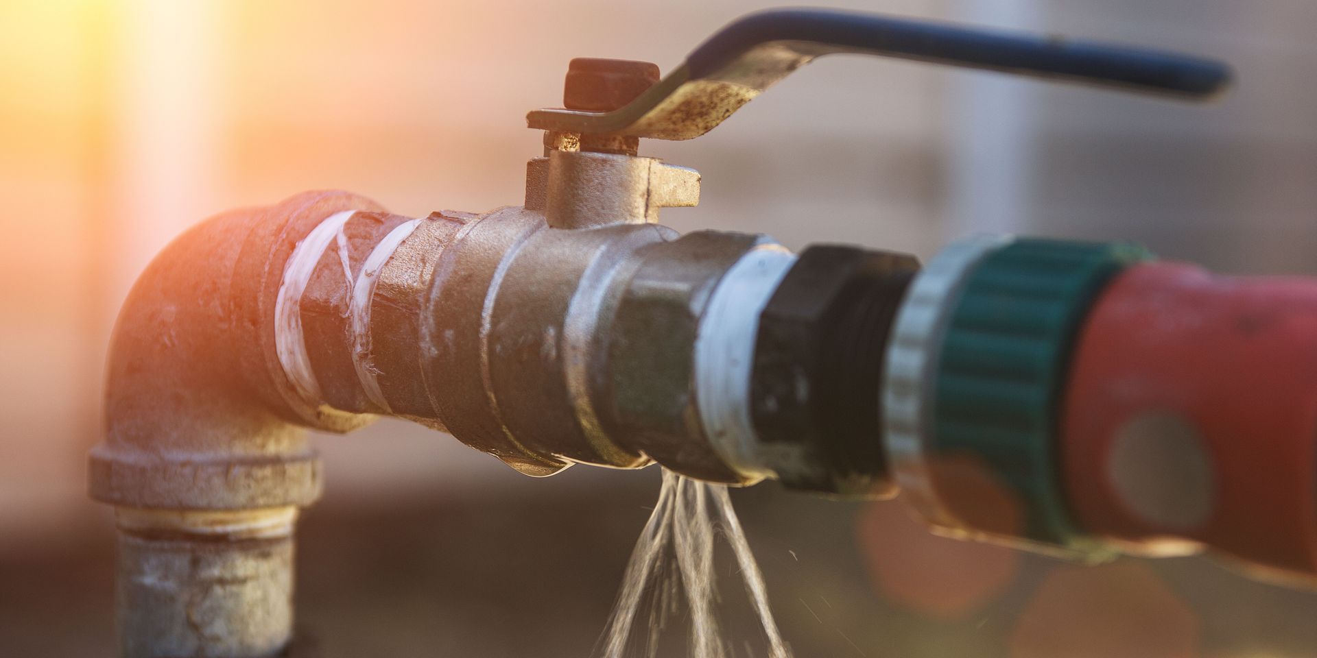 A close up of a water faucet with water coming out of it.