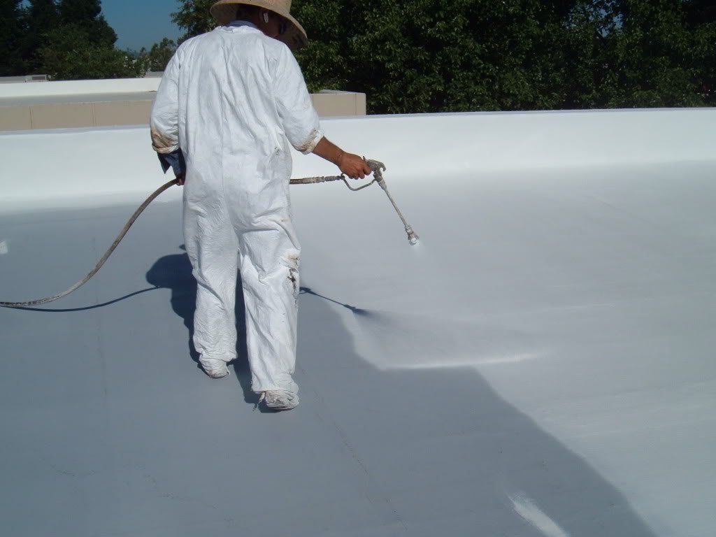 A man is spraying a roof with a sprayer