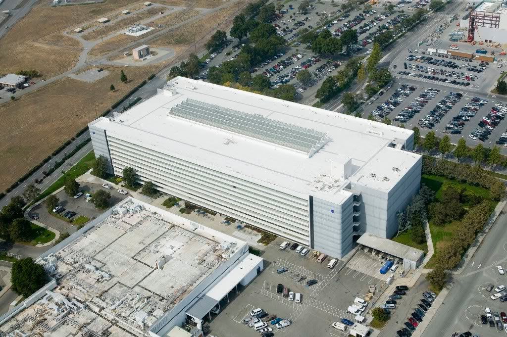 An aerial view of a large building with a parking lot in front of it