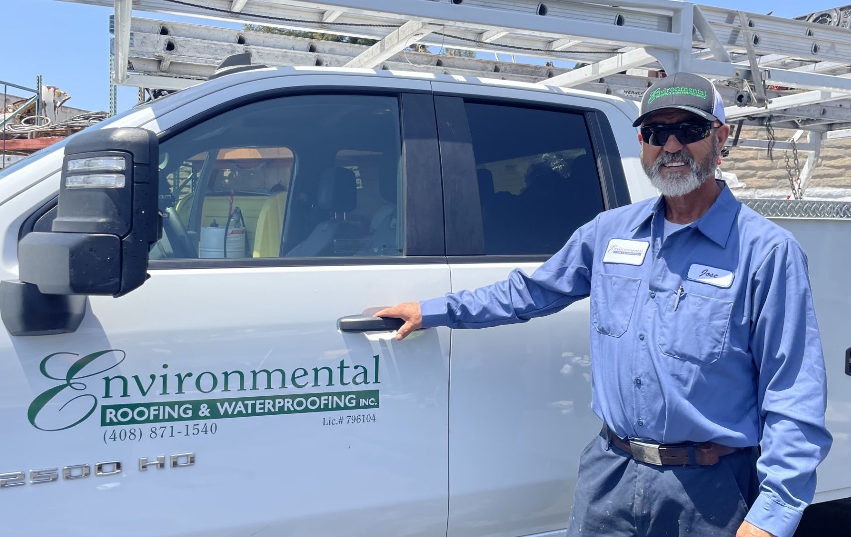 A white truck is parked in front of a building that says environmental