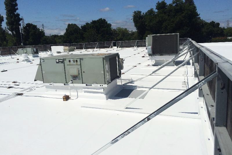 A white roof with a lot of air conditioners on it