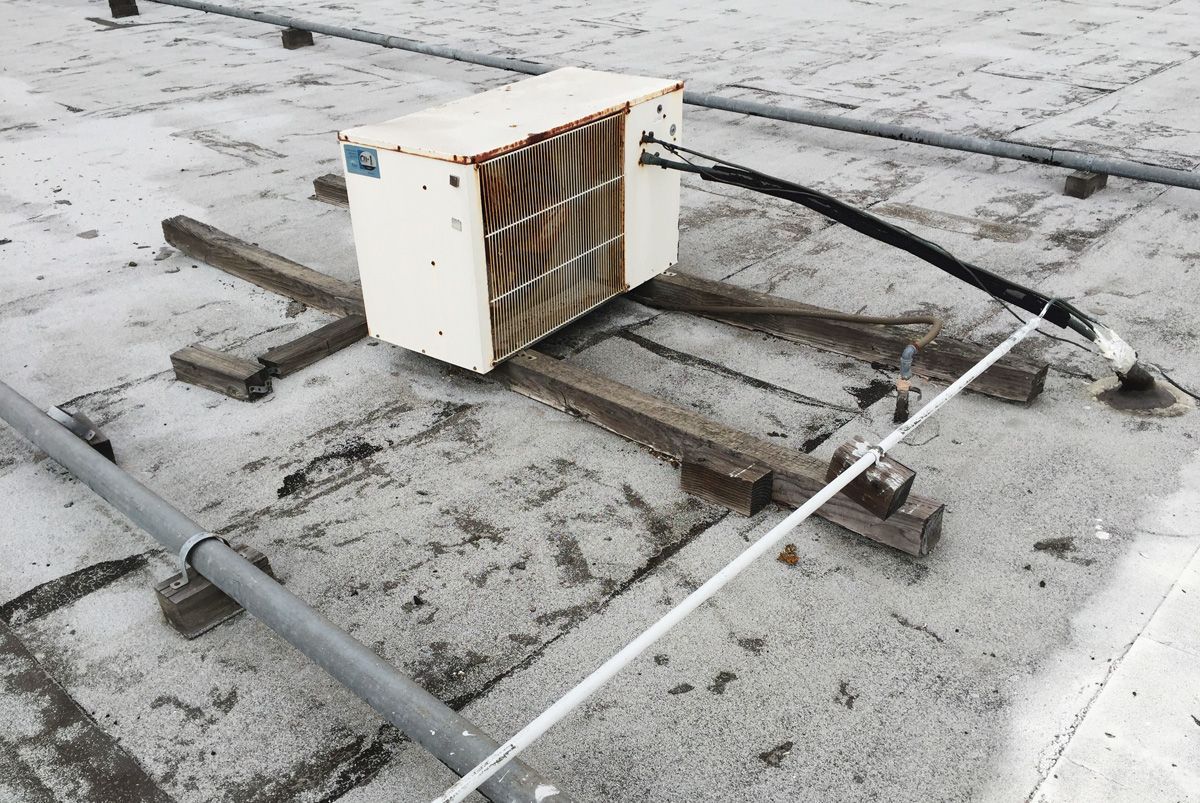 An air conditioner is sitting on the roof of a building.