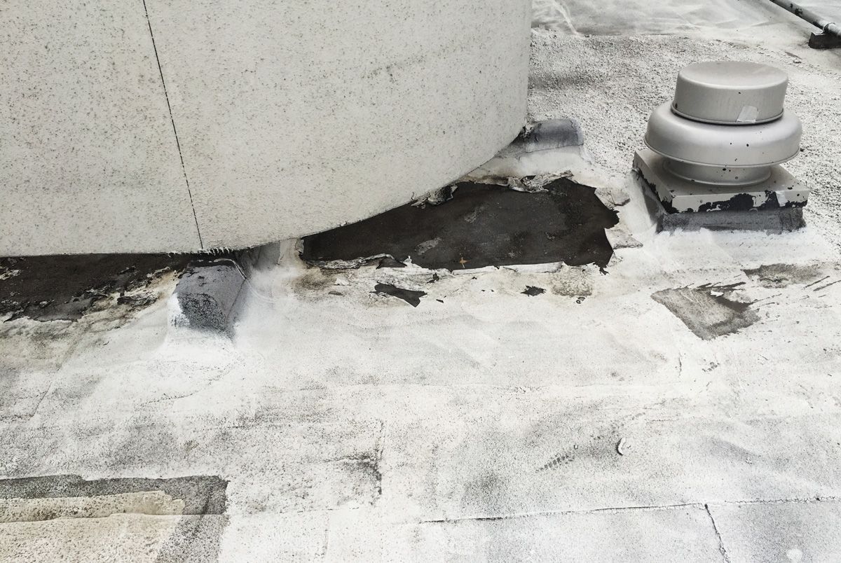 A black and white photo of a roof with a hole in it