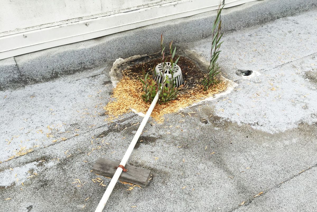 A broom is laying on the ground next to a hole in the ground.