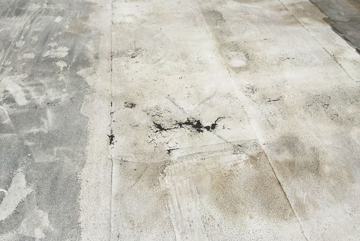 A close up of a concrete floor with a hole in it.