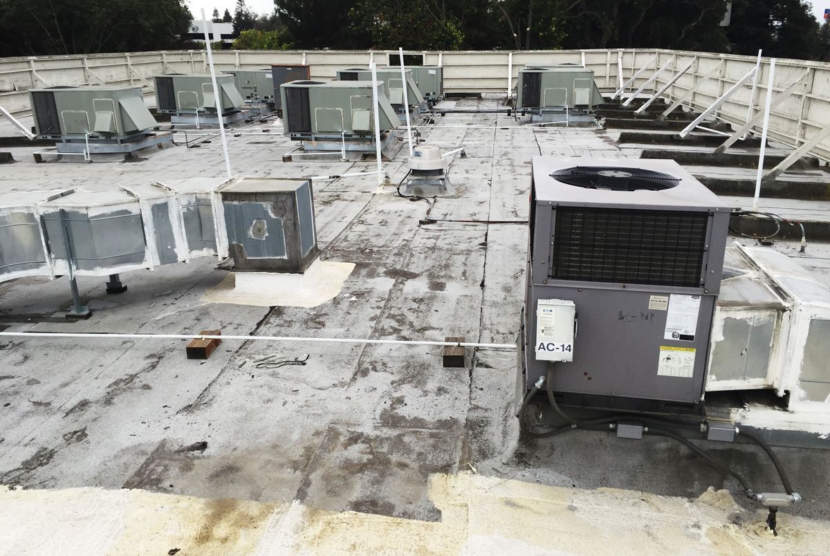 A roof with a lot of air conditioners on it