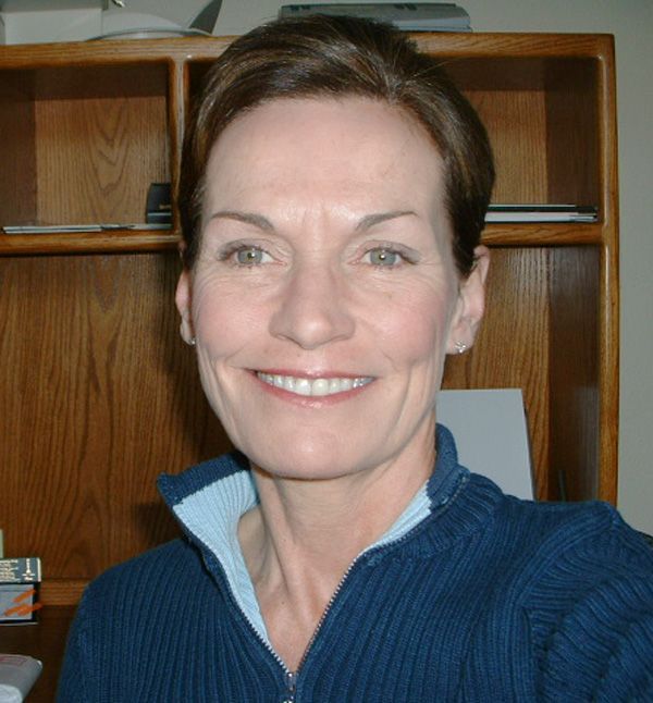 A woman in a blue sweater smiles for the camera