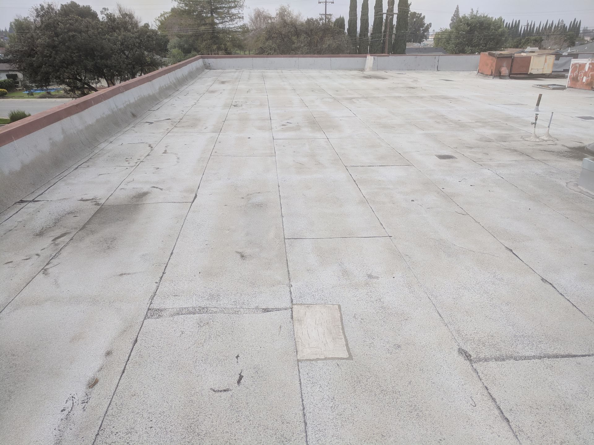 An empty roof with a few trees in the background