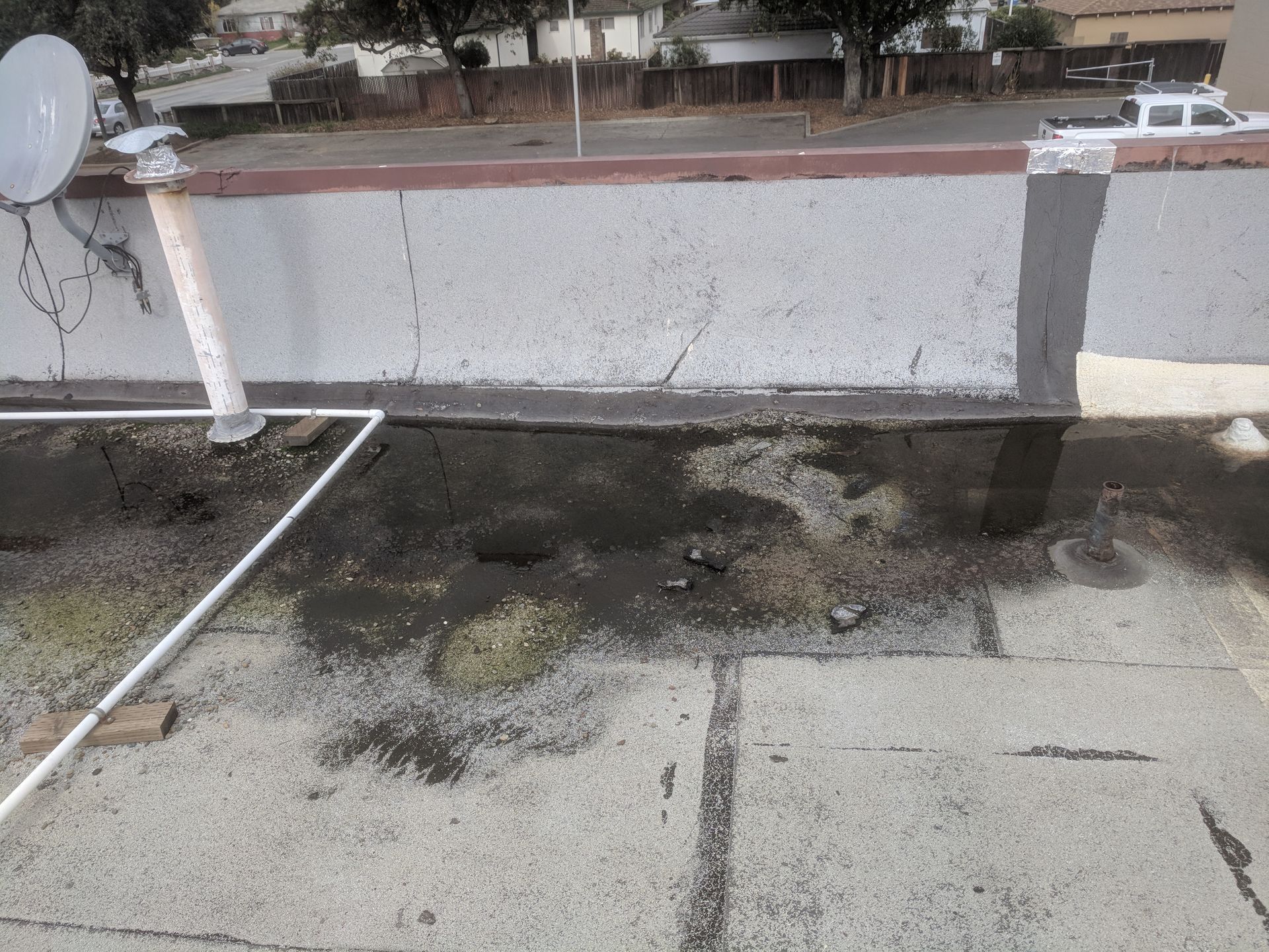 A satellite dish is sitting on the side of a building