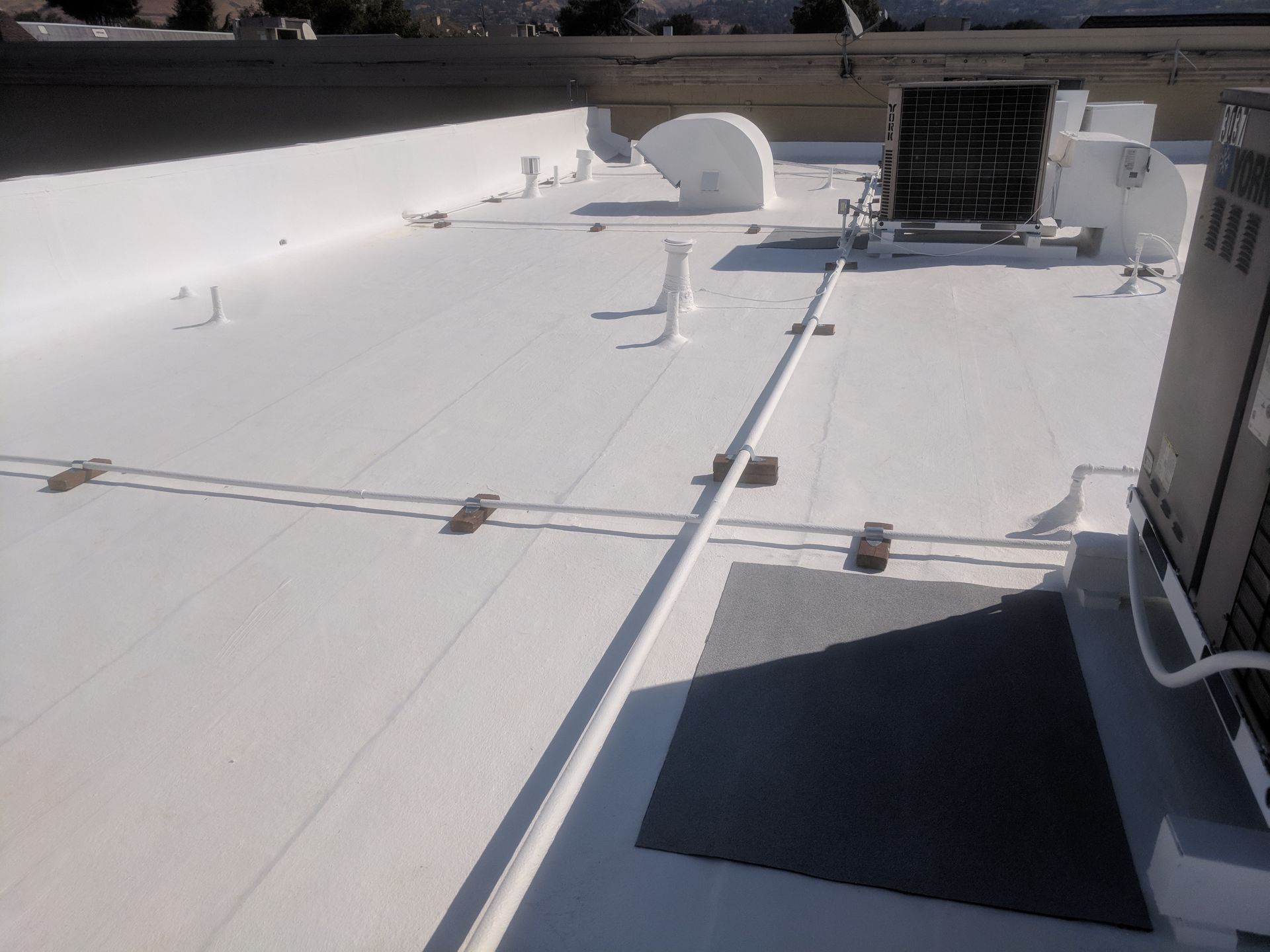 A white roof with a solar panel on it
