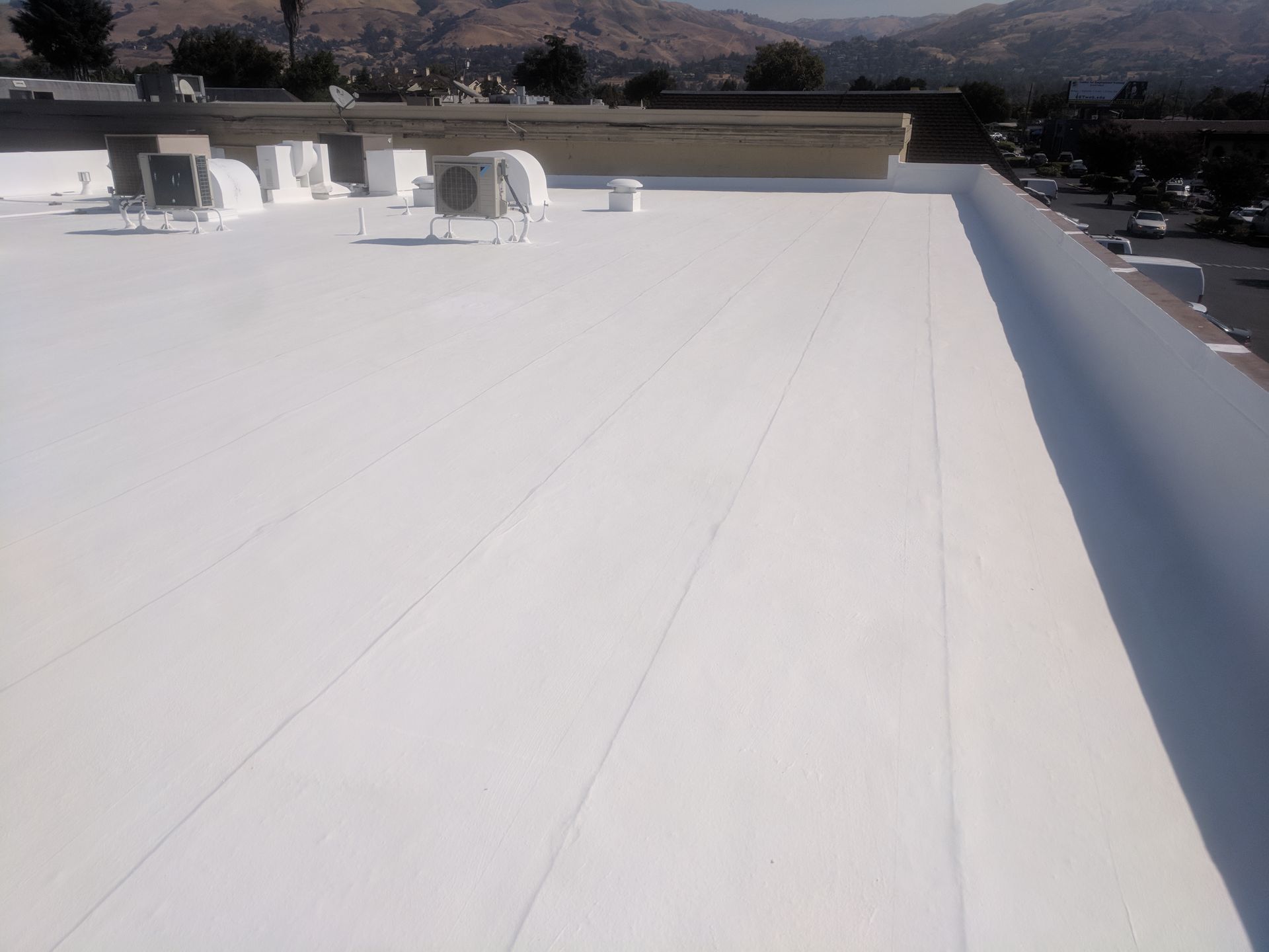 A white roof with a lot of air conditioners on it