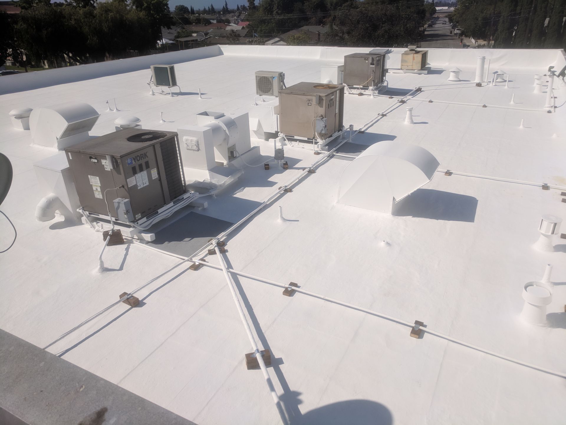 A white roof with a lot of air conditioners on it