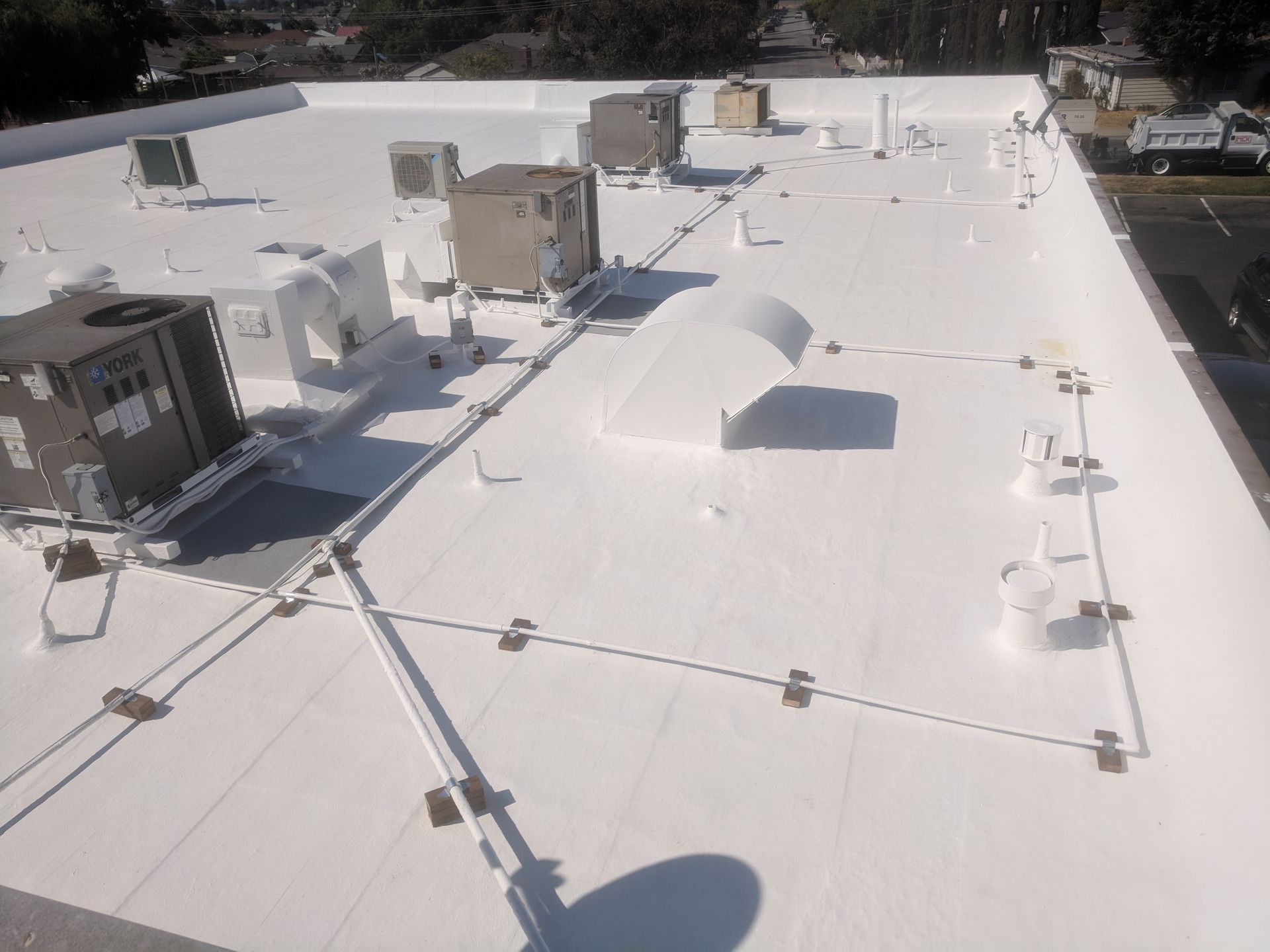A white roof with a lot of air conditioners on it