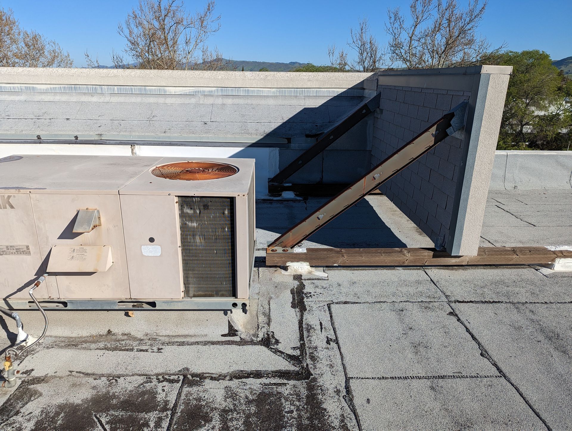 An air conditioner is sitting on the roof of a building.