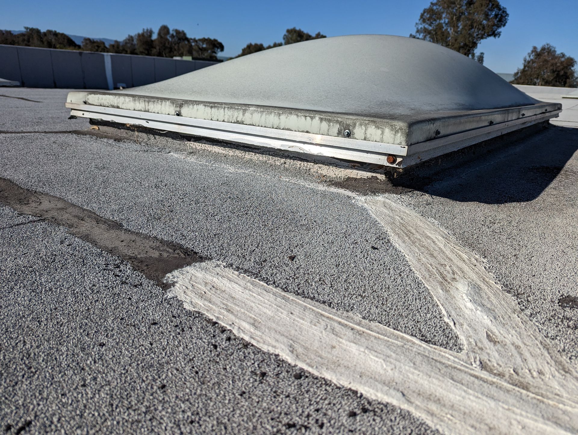A dome shaped skylight on top of a concrete roof