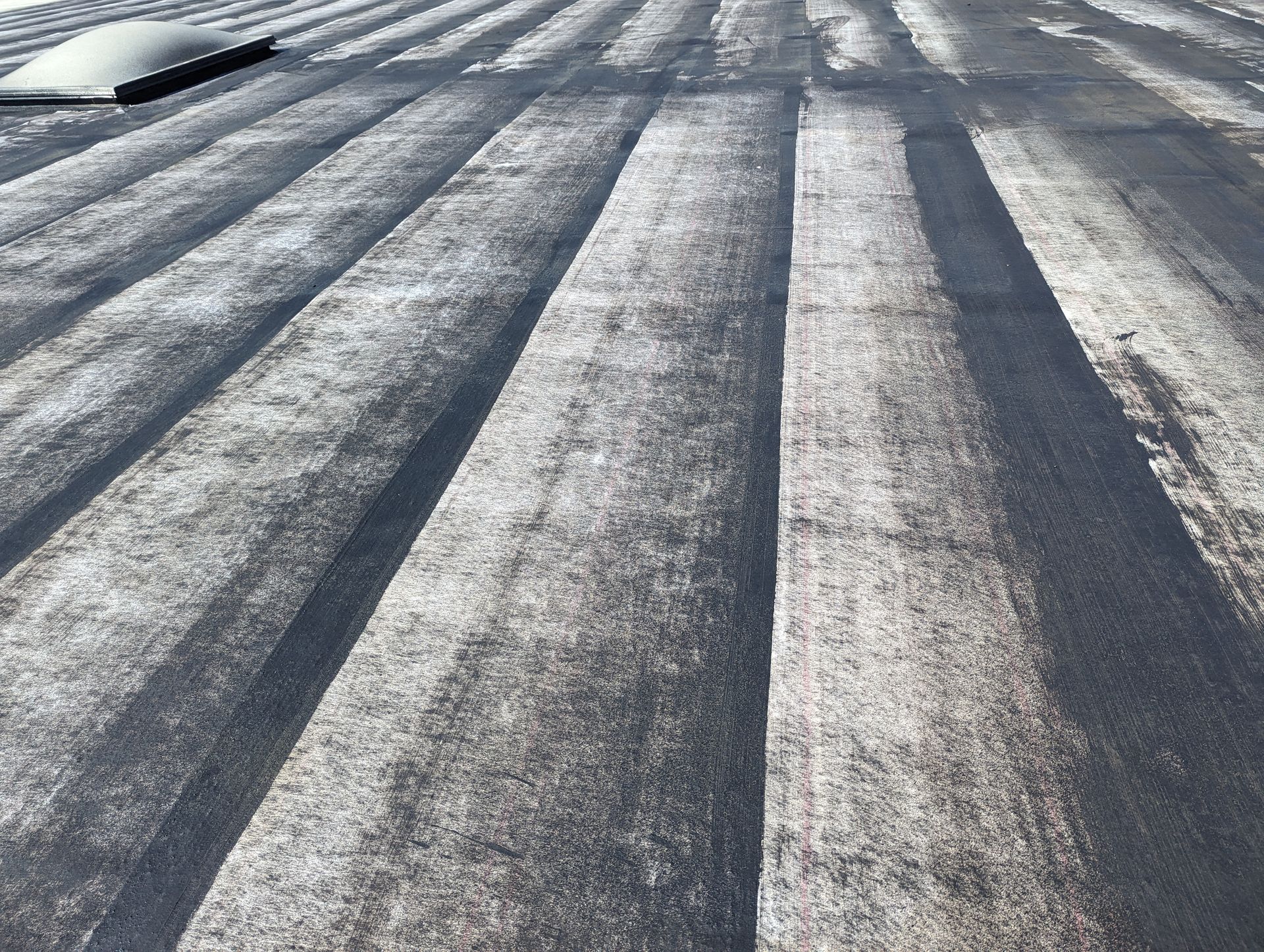 A close up of a roof with a skylight on it.
