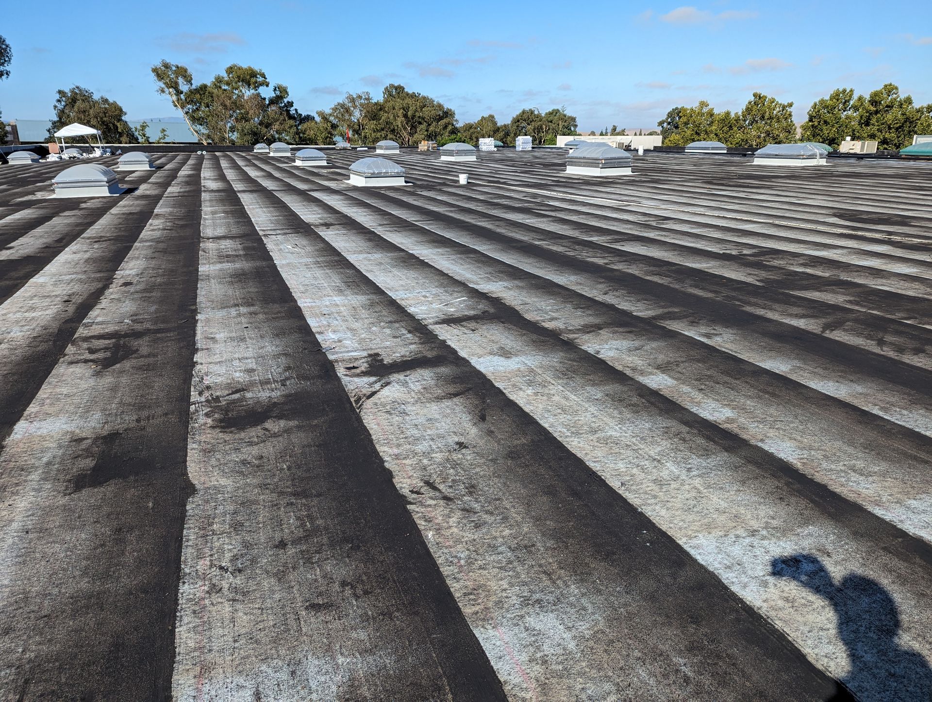 A shadow of a person is cast on the roof of a building