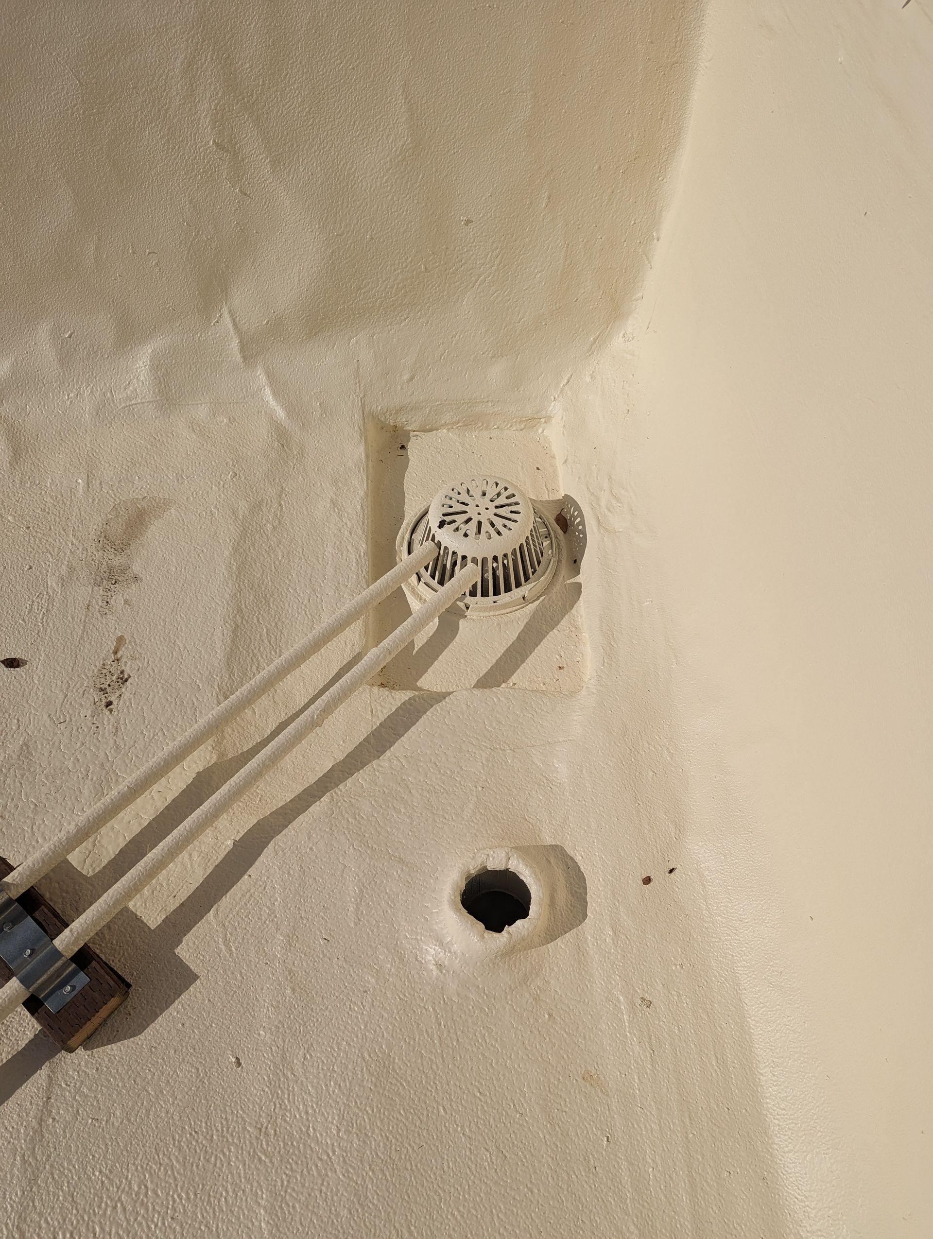 A close up of a white wall with a hole in it.