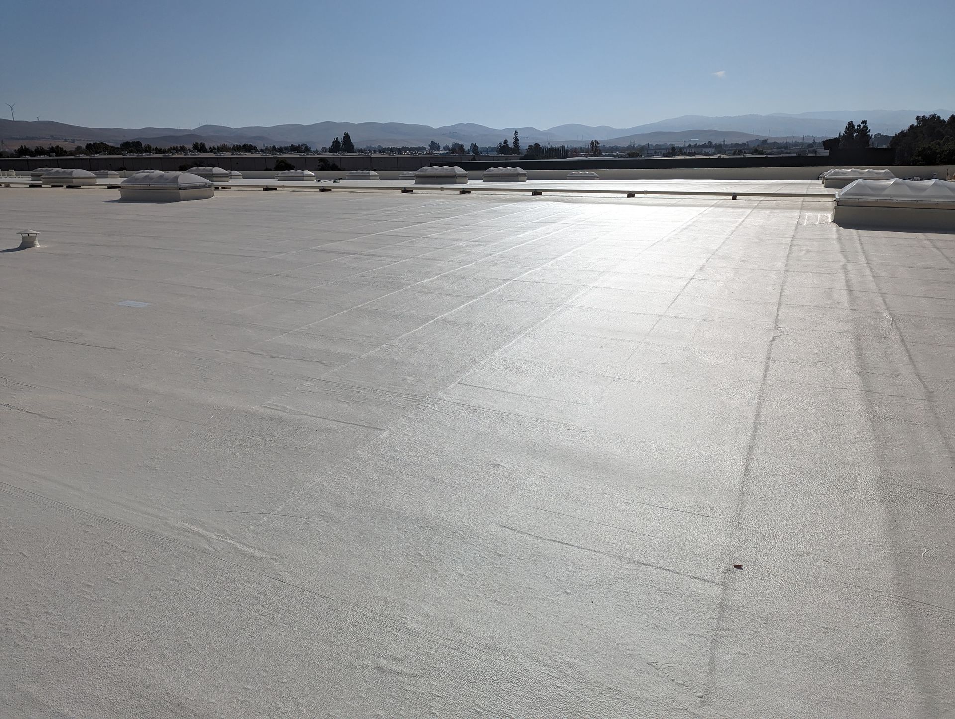 A large white roof with mountains in the background