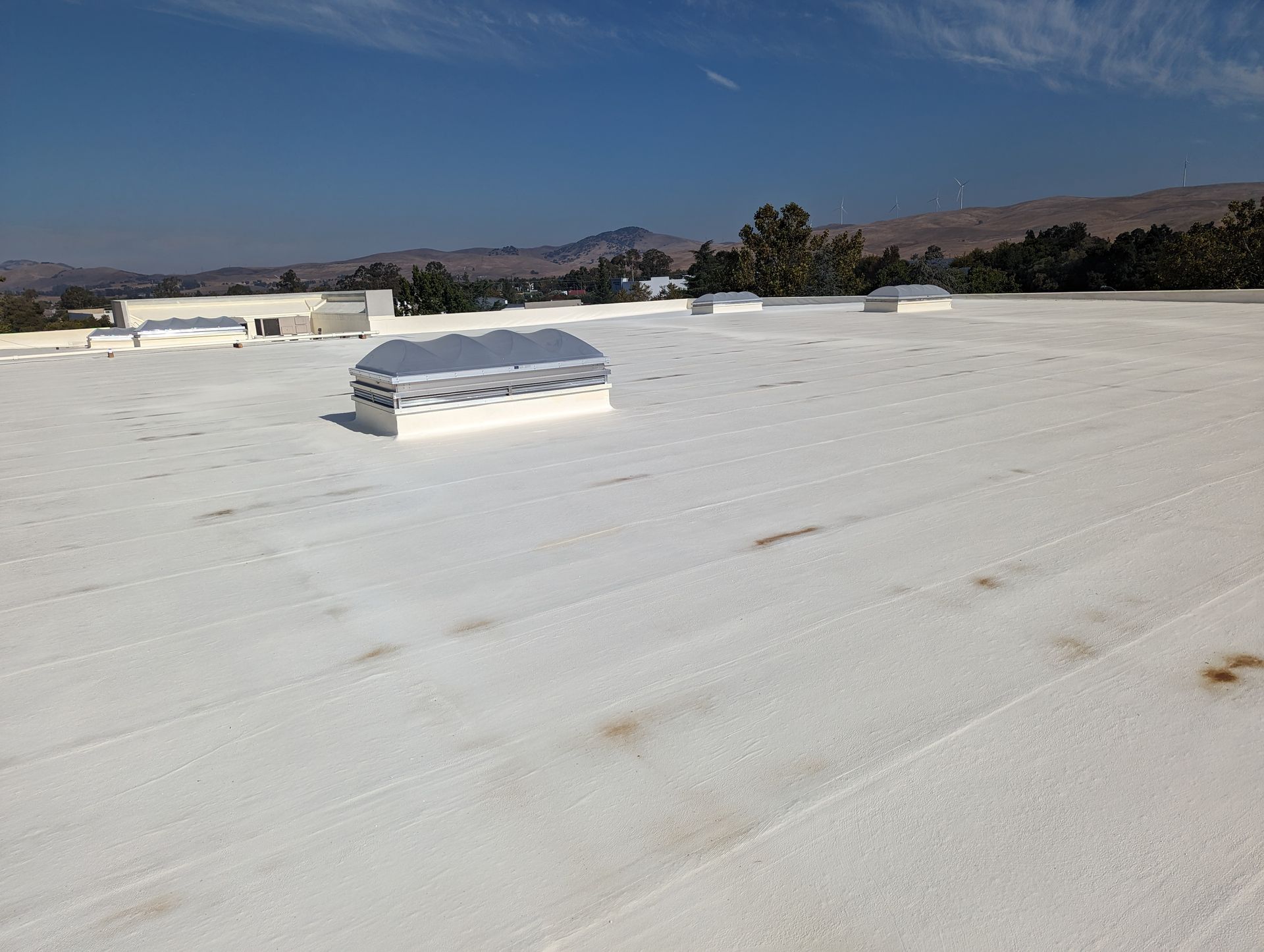 A white roof with a skylight on top of it
