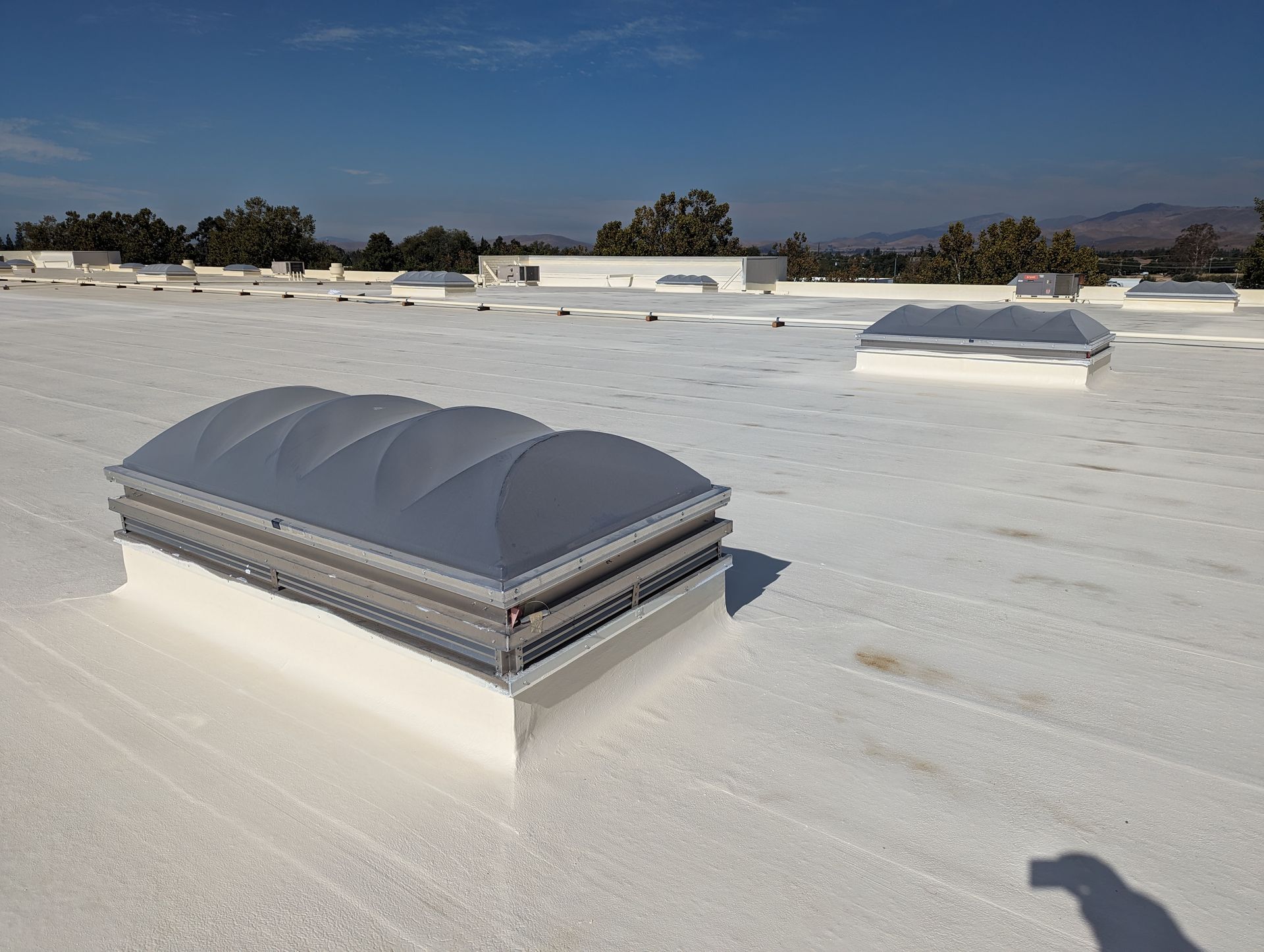 A white roof with a few skylights on it