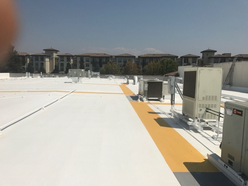 The roof of a building with a white roof and a yellow stripe on it.