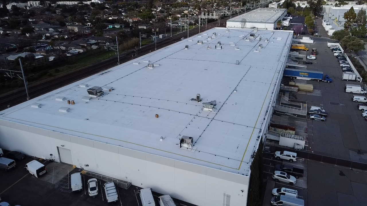 A man is spraying a roof with a hose