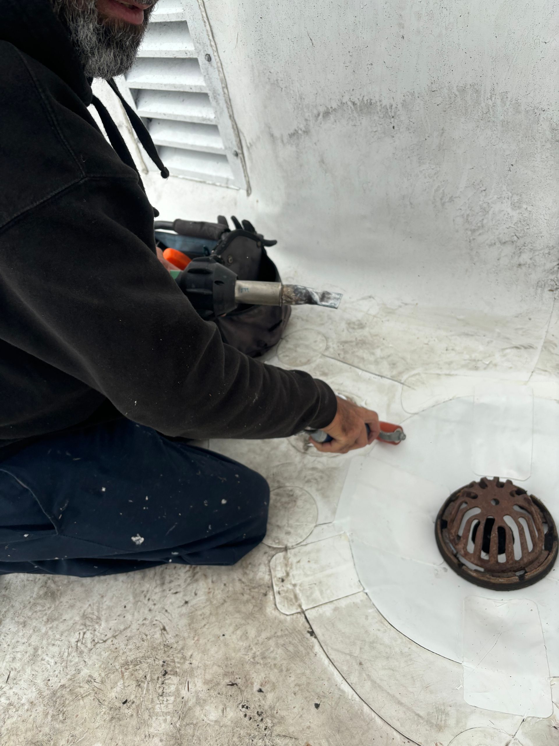 An aerial view of a building under construction with a white roof.