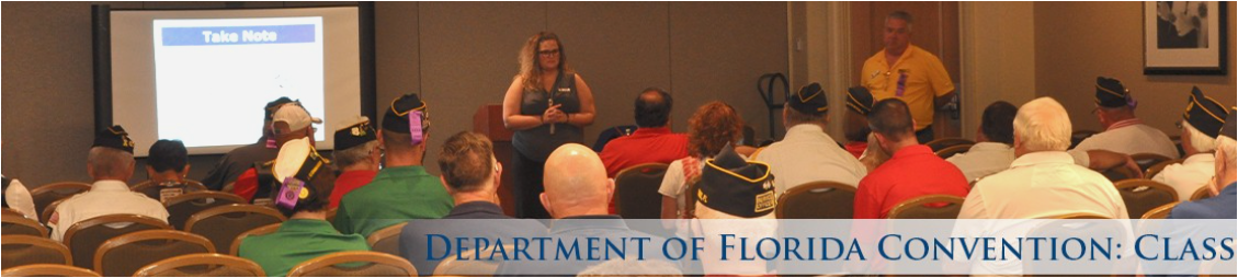 A woman is giving a presentation to a large group of people at the department of florida convention class