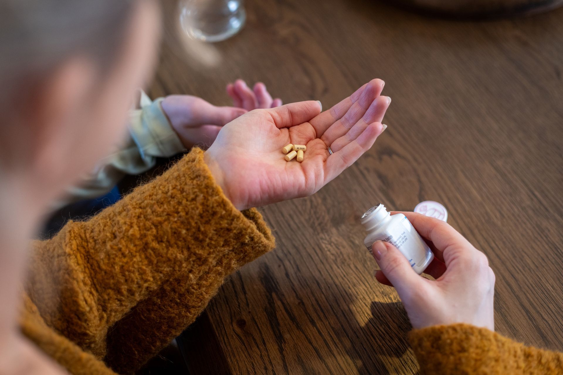 A woman is holding a bottle of pills in her hand.