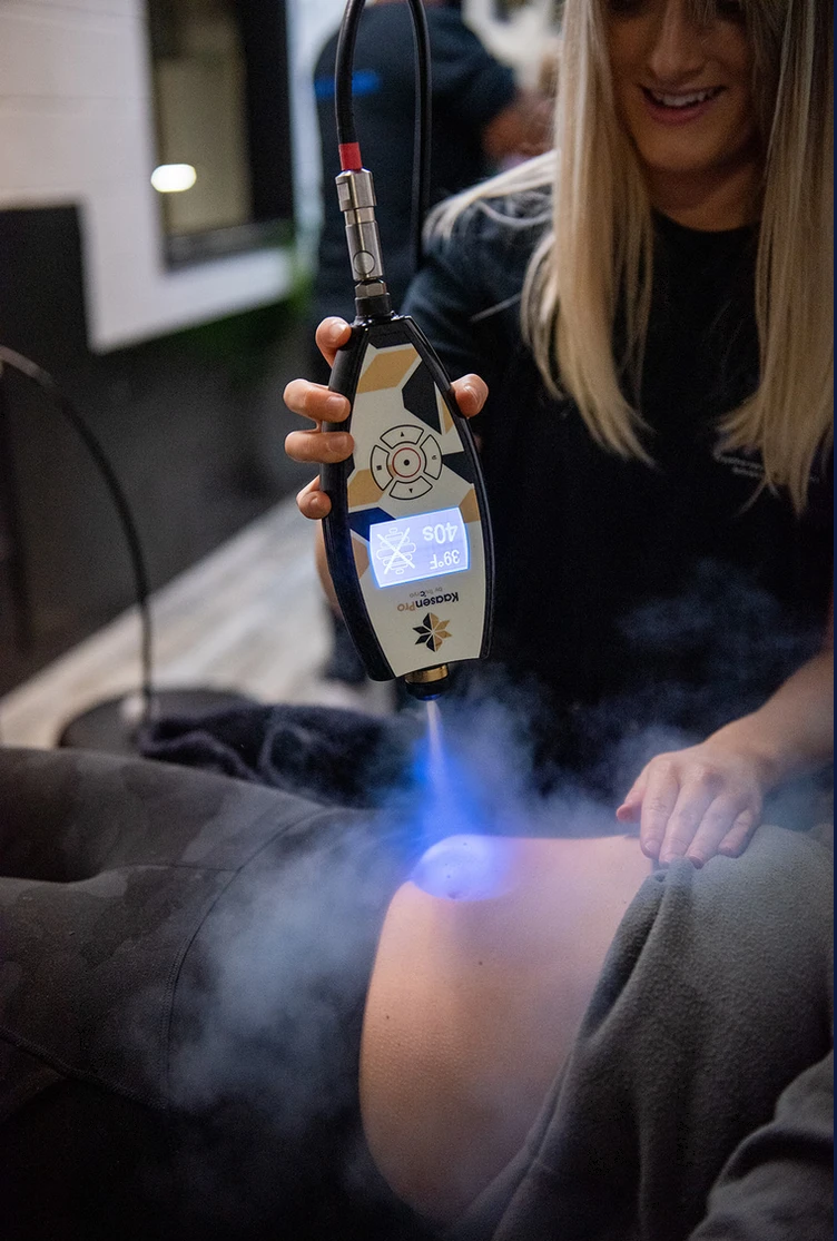 A woman is getting a cavitation treatment on her stomach.