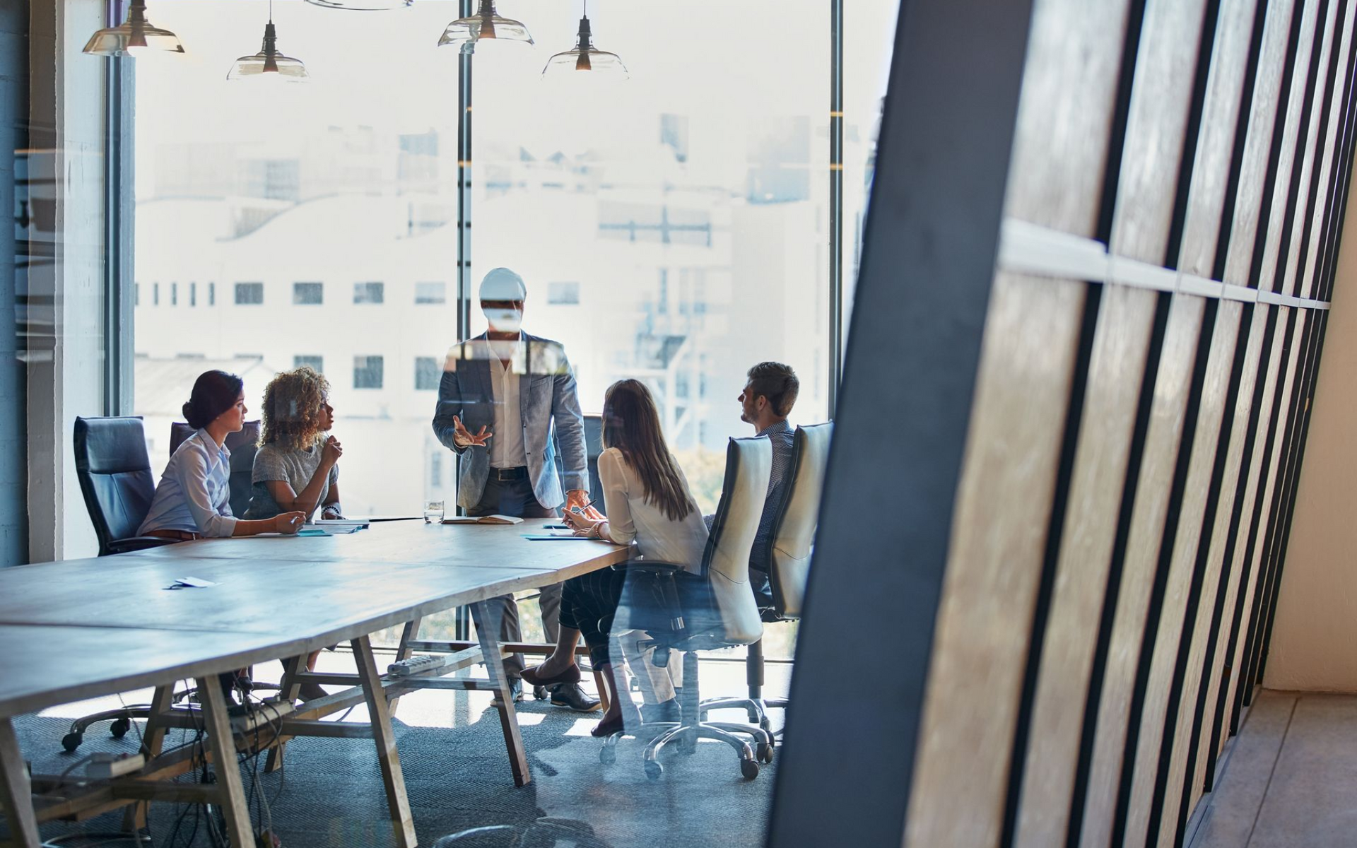 Business meeting in a conference room with large window. 