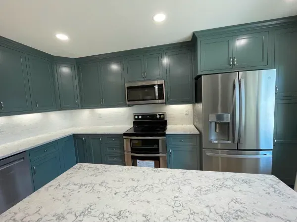 A kitchen with blue cabinets and stainless steel appliances