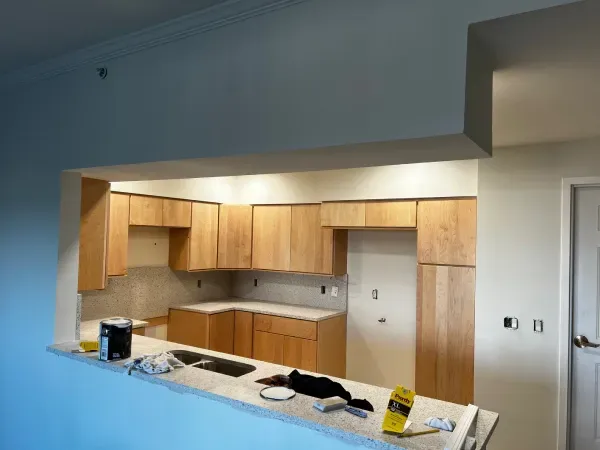 A kitchen with wooden cabinets and white counter tops