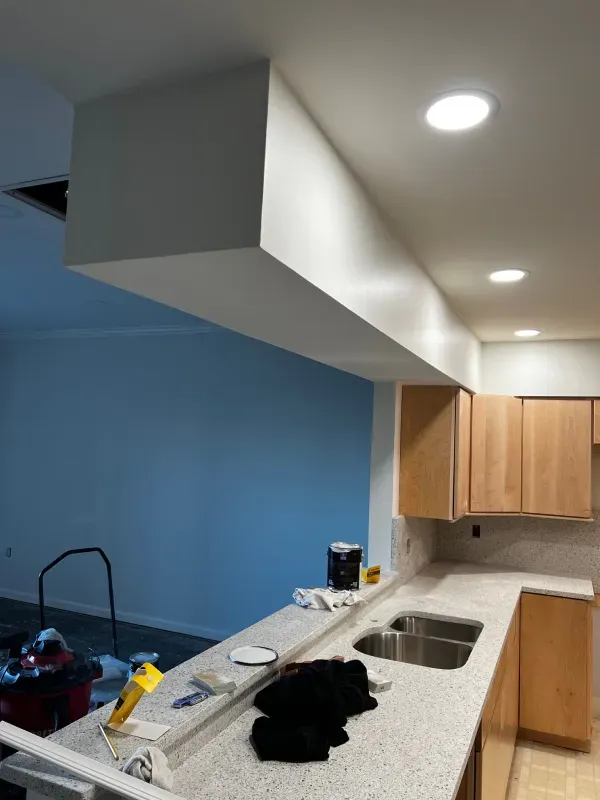 A kitchen with a sink and a blue wall